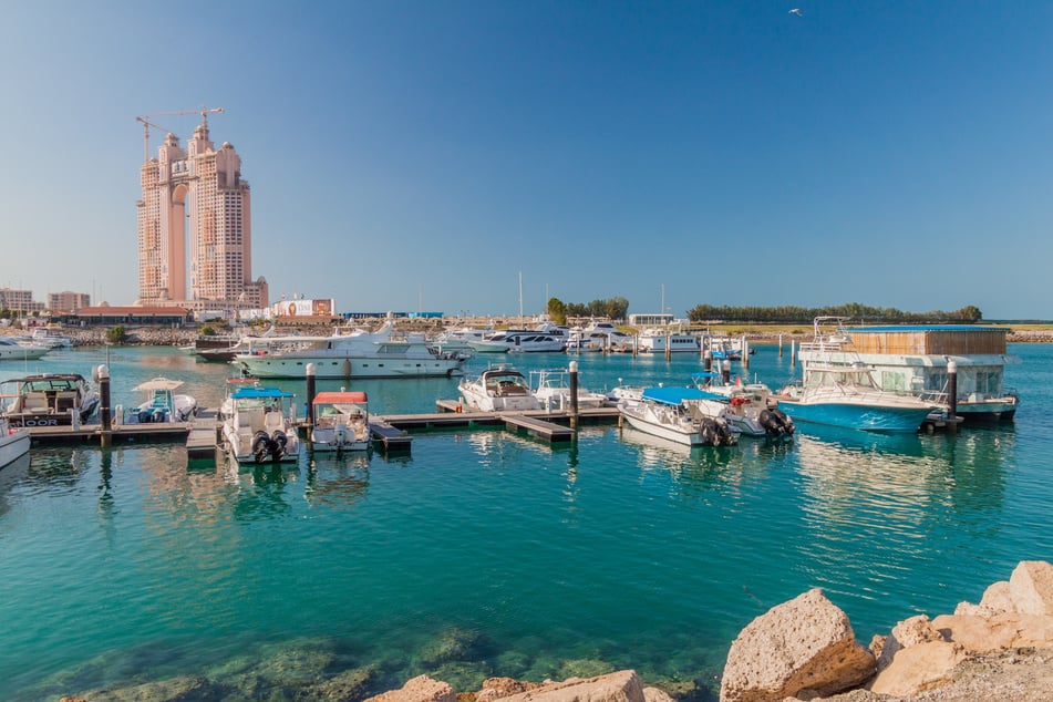 ABU DHABI, UAE - MARCH 7, 2017: Boats in Marina Breakwater, United Arab Emirates. Fairmont Marina Residences building in the backgroun